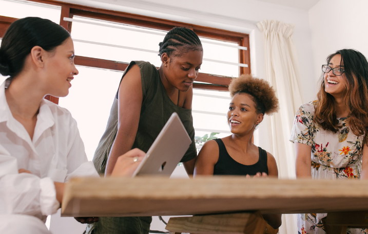 4 women of colour gathered around a table