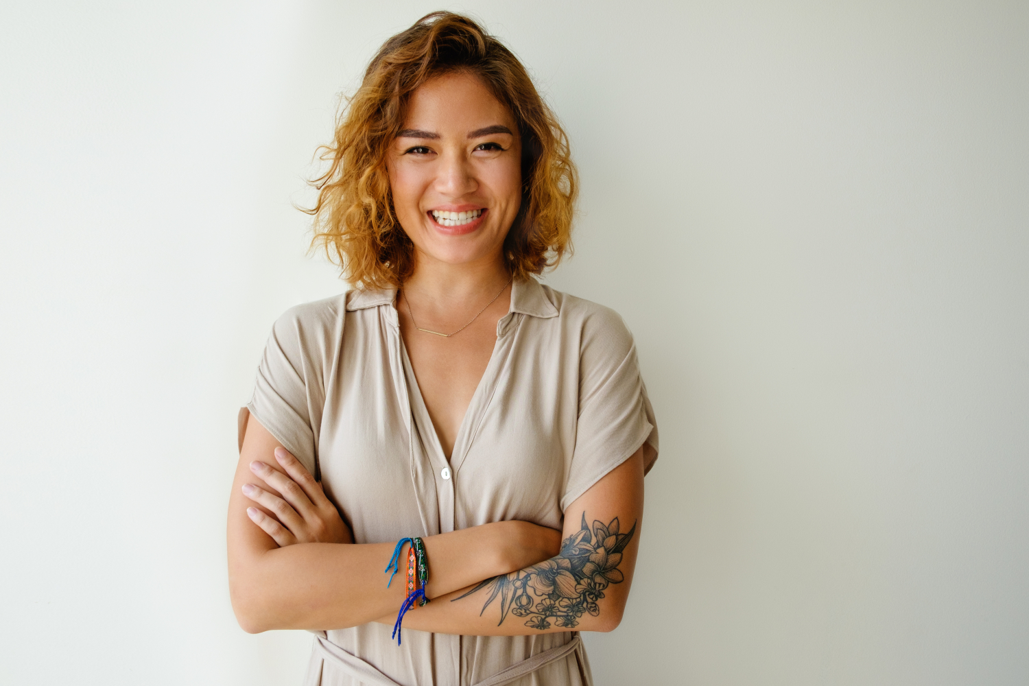 Young woman smiling and standing against wall