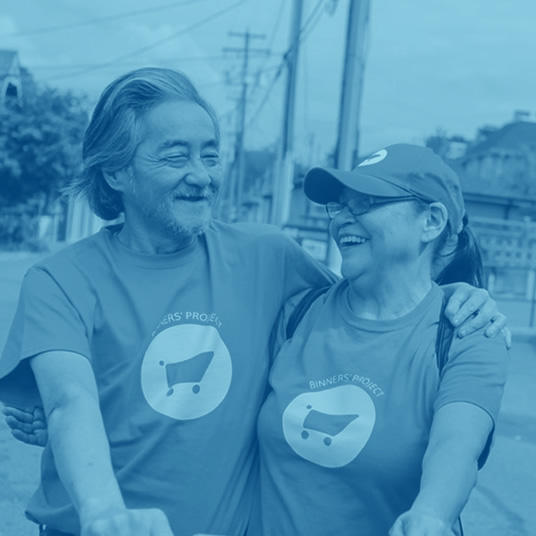 Two smiling people with an arm around one another