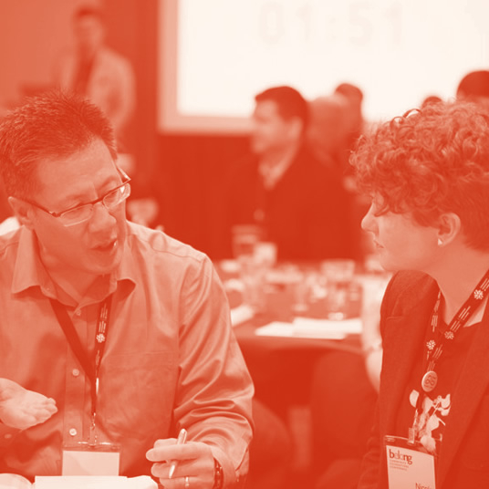 Two people speaking with each other at a table