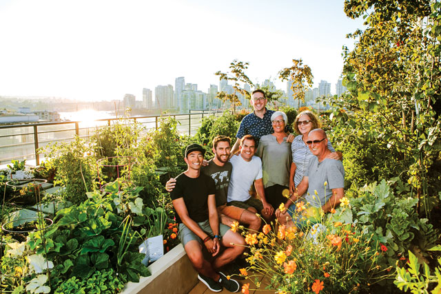 Photo of a smiling group of men and women in a garden on the waterfront