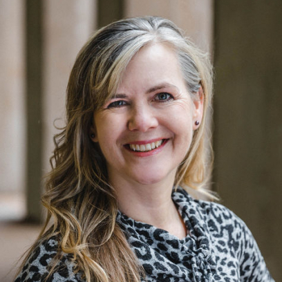 Headshot of Kristin Helgason, a smiling woman with light eyes and dirty blonde hair 