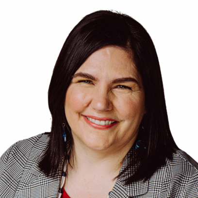 Headshot of Carmen Lansdowne,a smiling woman with shoulder length brown hair wearing a black and white patterned blazer and blue earrings