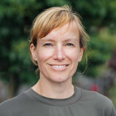 Headshot of Chris Little, a smiling woman with blonde hair and light eyes wearing a grey blouse