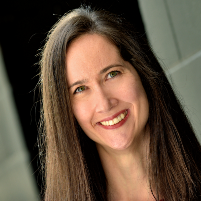 Headshot of Kim Macphee, a smiling woman with long brown hair and light eyes