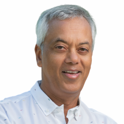 Headshot of Praveen Varshney, a smiling man with white hair wearing a light shirt patterned with short coloured lines