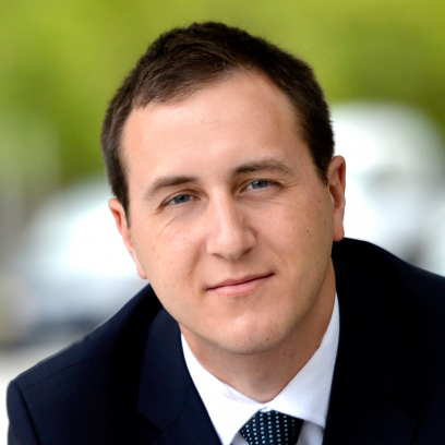 Headshot of Rob Gagliano, a smiling man with dark short hair and light eyes, wearing a suit and tie.