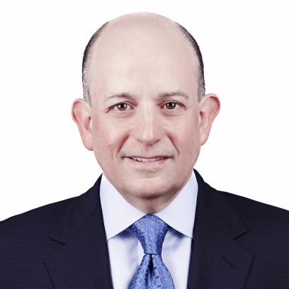 A smling man with brown eyes wearing a suit and tie