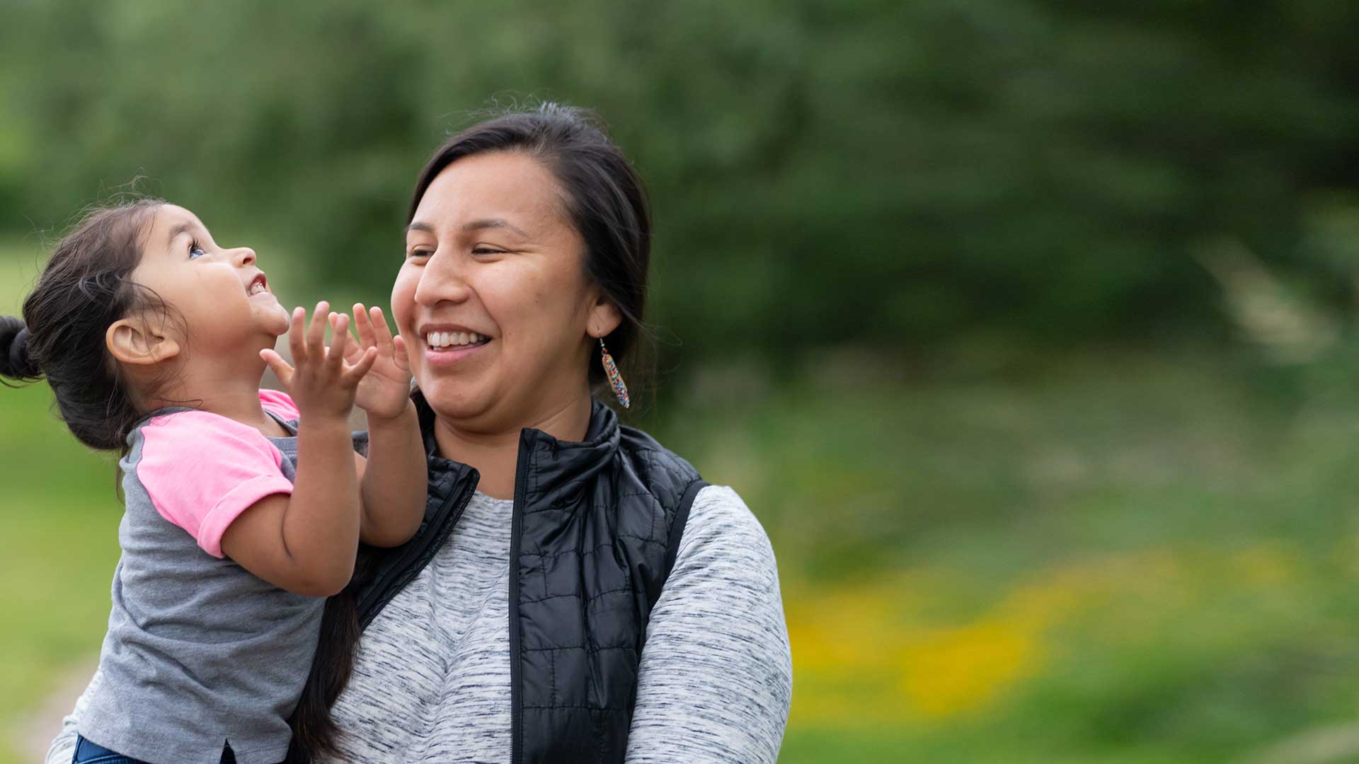 Child laughing in arms of an adult