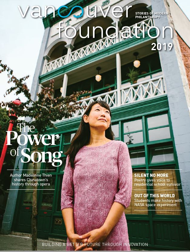 Magazine cover of an asian woman standing in front of a green and grey three-storey building, text reading "Vancouver Foundation 2019 The Power of Song"