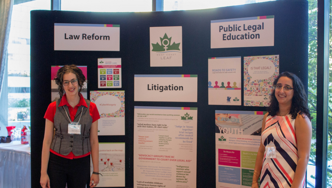 Two women standing before their presentation display with the sign "West Coat Leaf" at the top