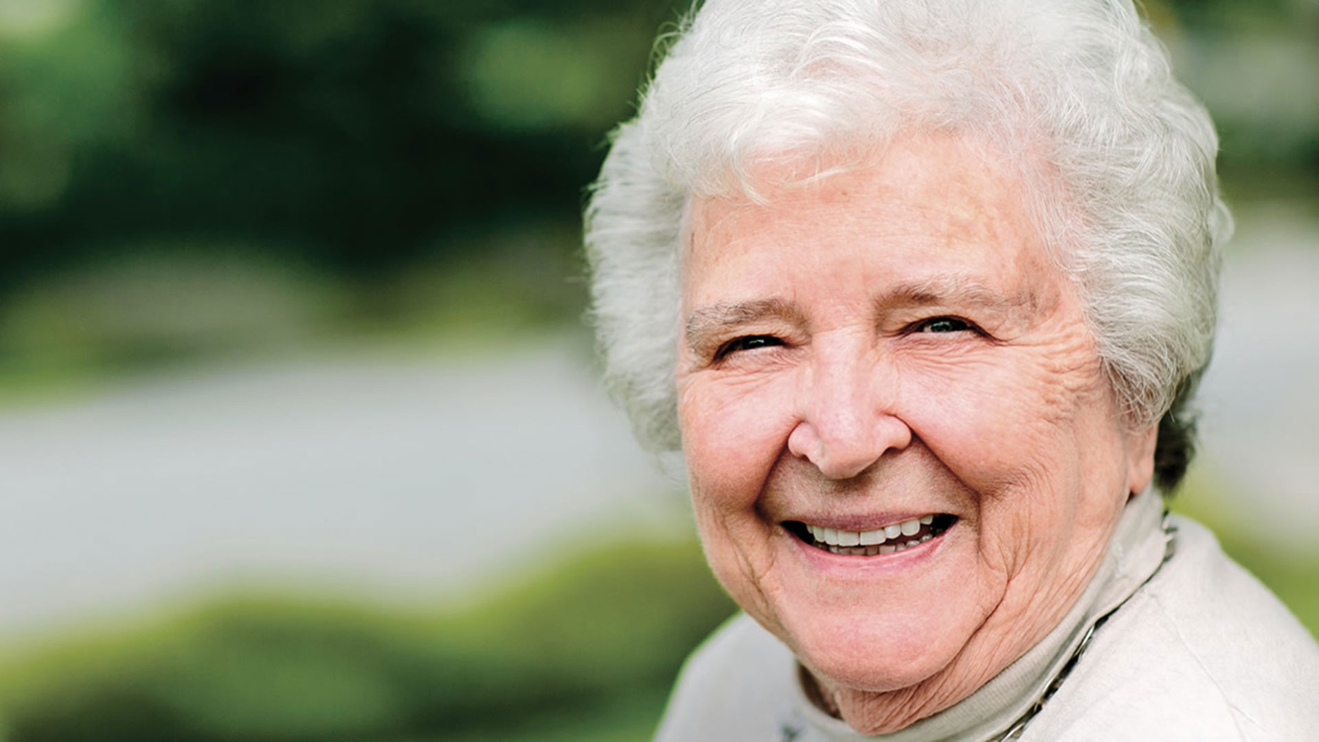 A pictore of Ann Dyke, an elderly woman with white hair, smiling