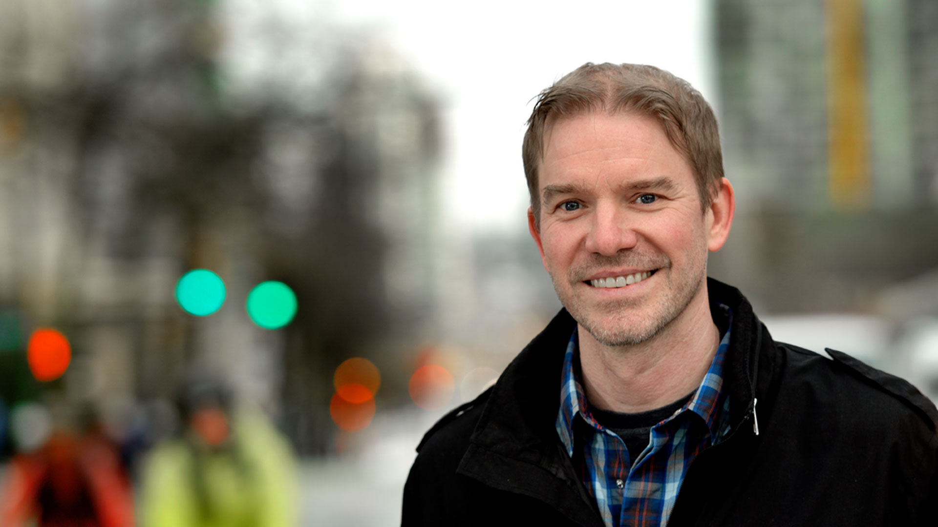 A picture of Derek Wills, a man with short light brown hair and light eyes, smiling 