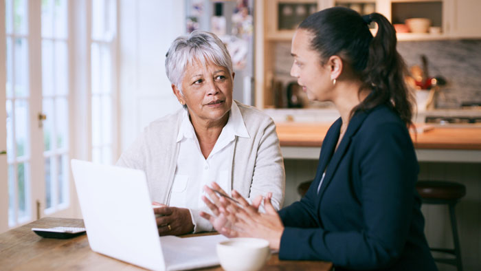 Older woman consults with her financial advisor with a laptop. Credit Alexander Ford.