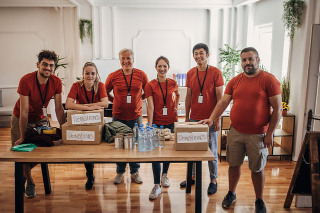 Volunteers packaging donations wearing matching orange T-shirts