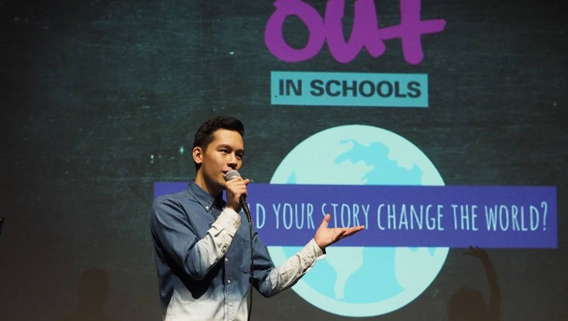 A person speaking on stage for "Out in Schools"