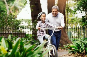 Once you learn, you never forget An older man helping a child learn how to bike