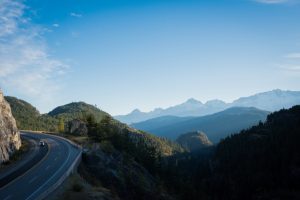 Highway 99 British Columbia Lush, forested mountainside view of a car driving on a winding road