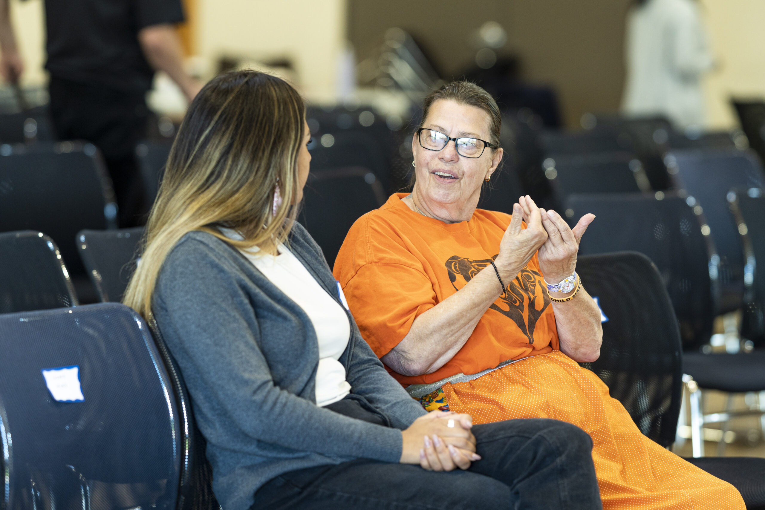 Elder-in-Residence Debra Trask chats with participant Qwu'yum'aat Elliott before policy presentations.