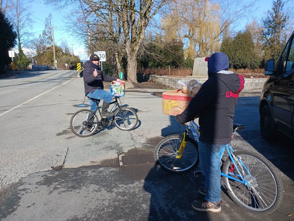 Two men on bicycles prepare tp deliver food.