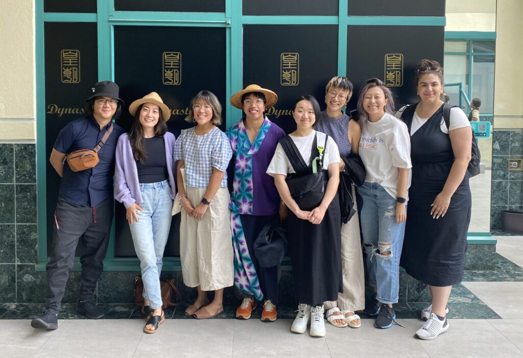 A group of people stand in front of a building smiling.