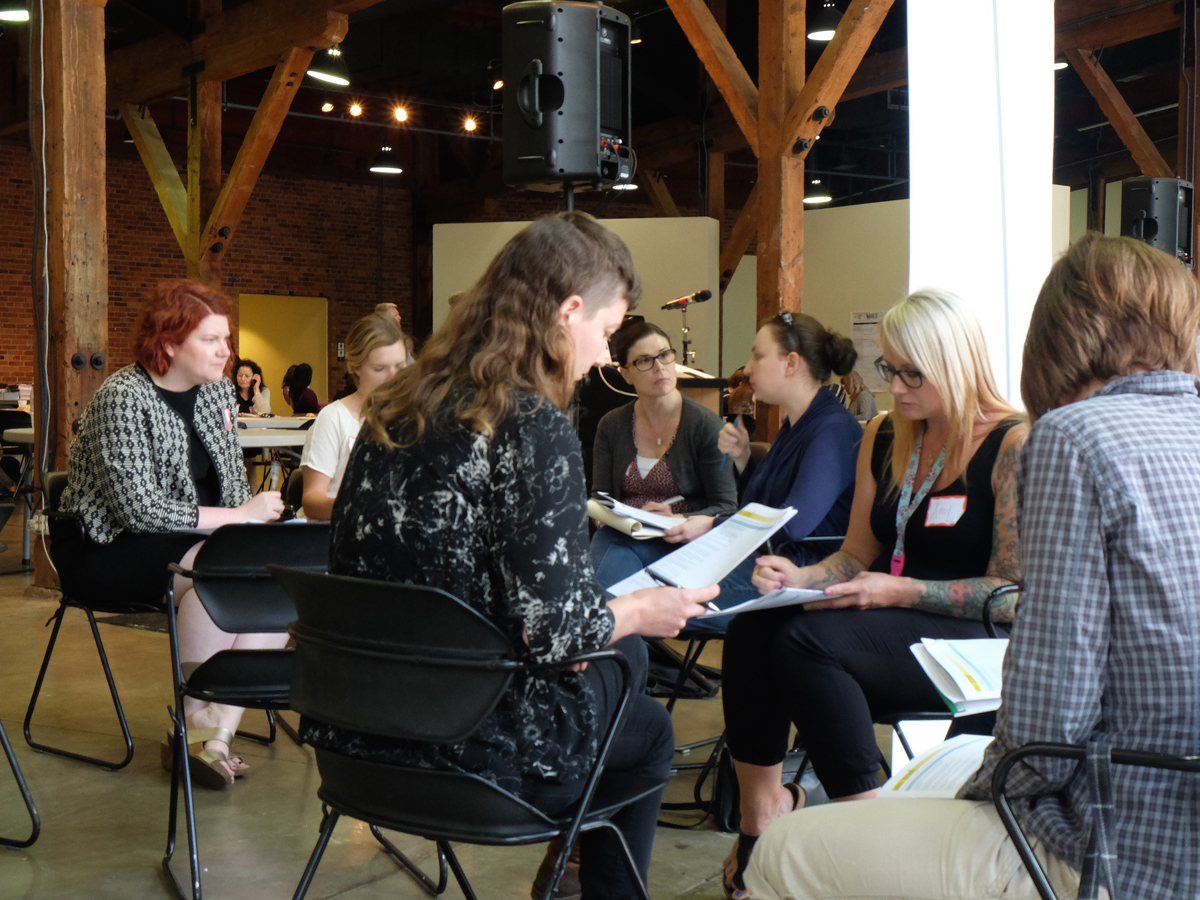 A group of women sitting together and looking over information packets