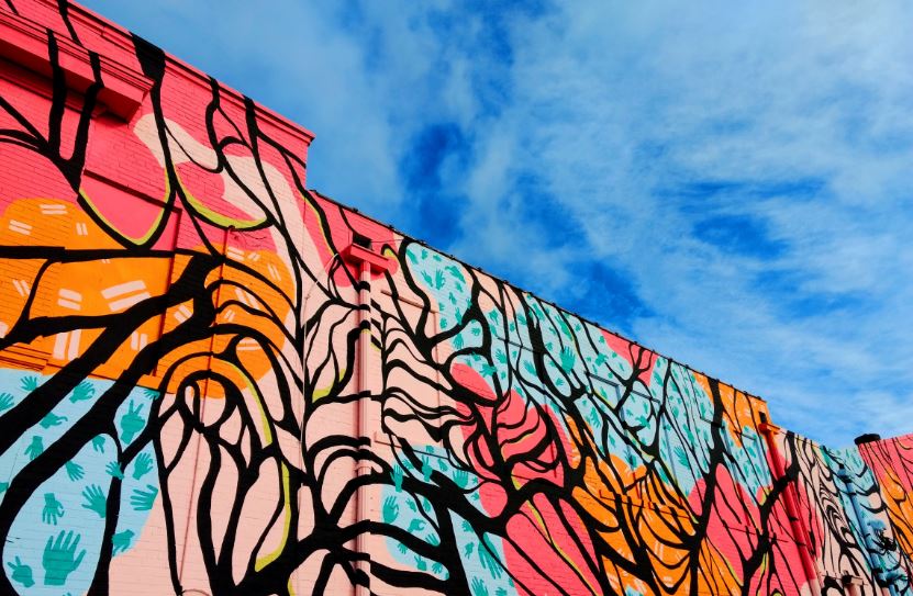 Abstruct mural on the side of a building in red, orange, blue and black. Credit to Adam Bouse and Unsplash