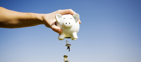 piggy%2520bank%2520pouring%2520out-WEB_0 A hand holding a piggy bank that is spilling money from the bottom